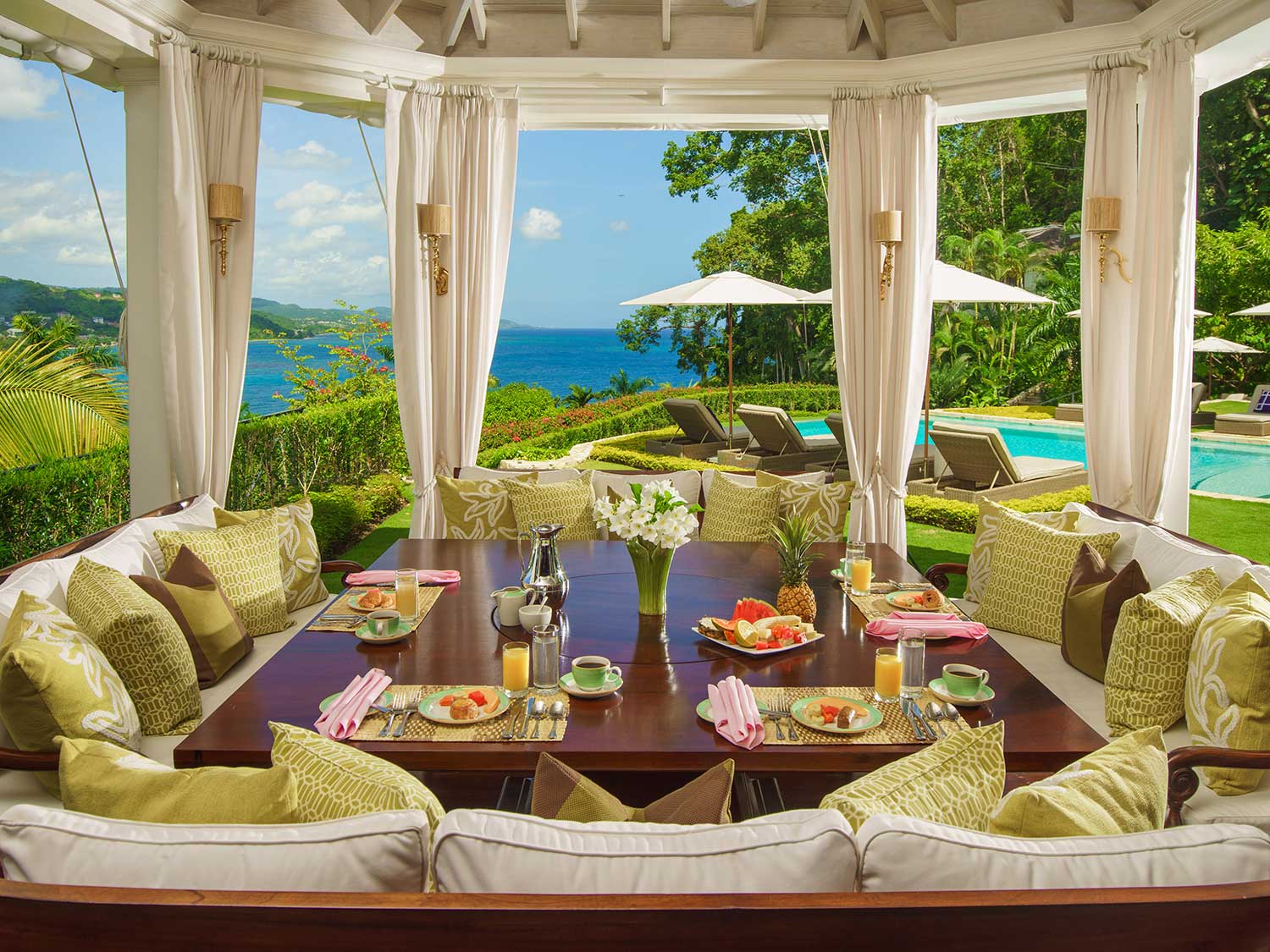 An outdoor breakfast nook under a pagoda with curtains