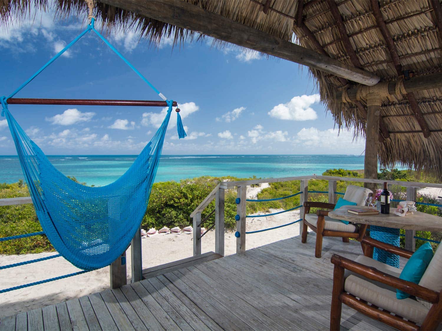 A hammock and lounge area overlooking a beach view at the Anegada Beach Club.