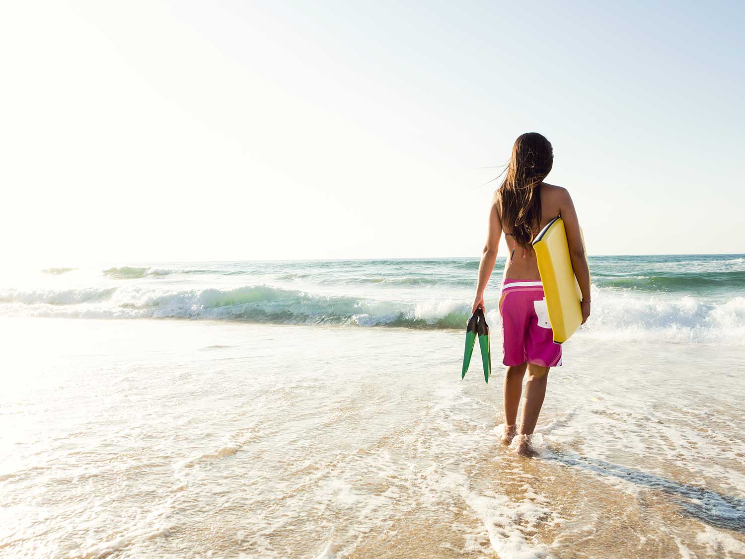 Woman on beach with bodyboard