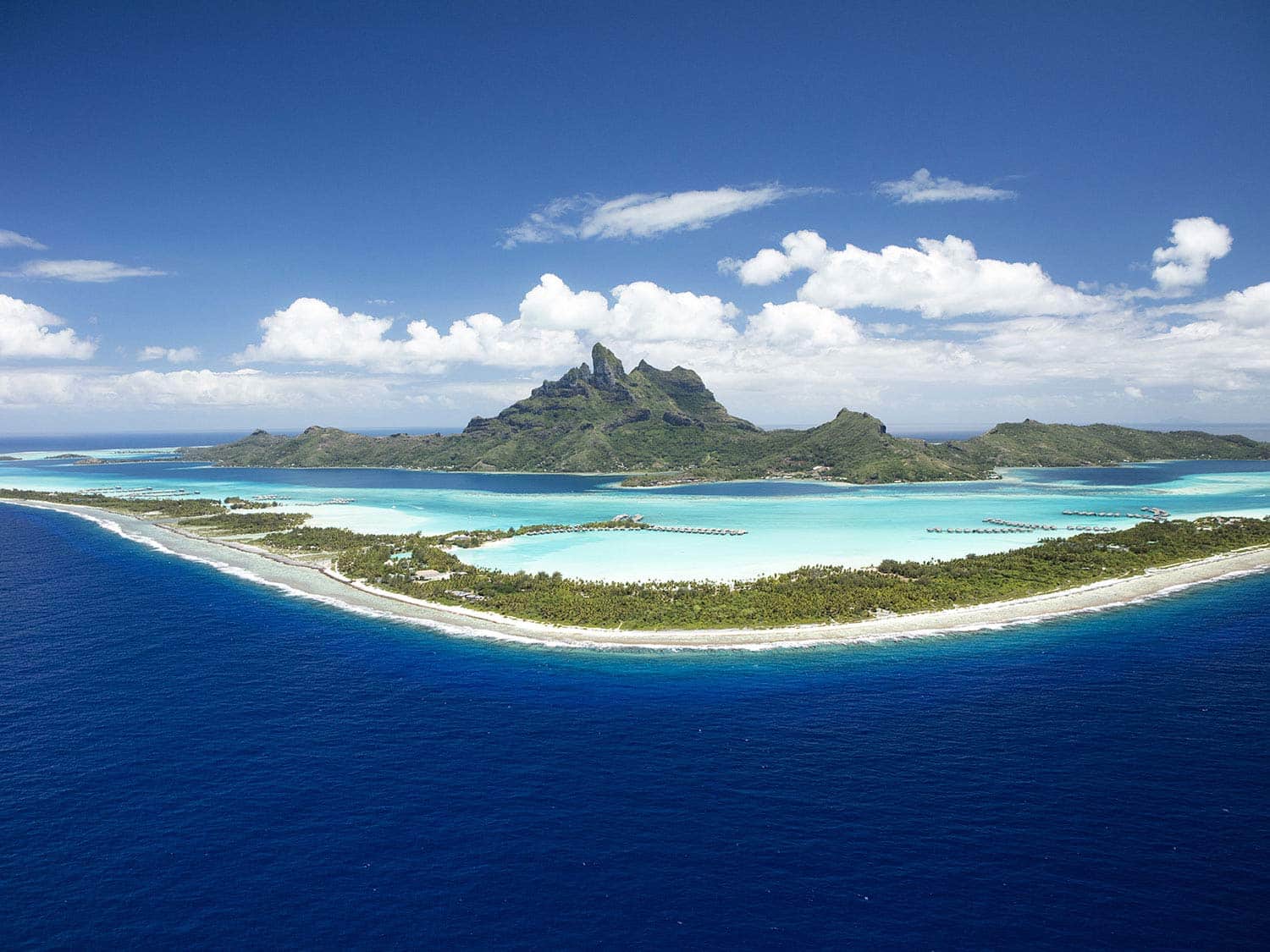 A large panoramic landscape of a beach and islands surrounded by the ocean.