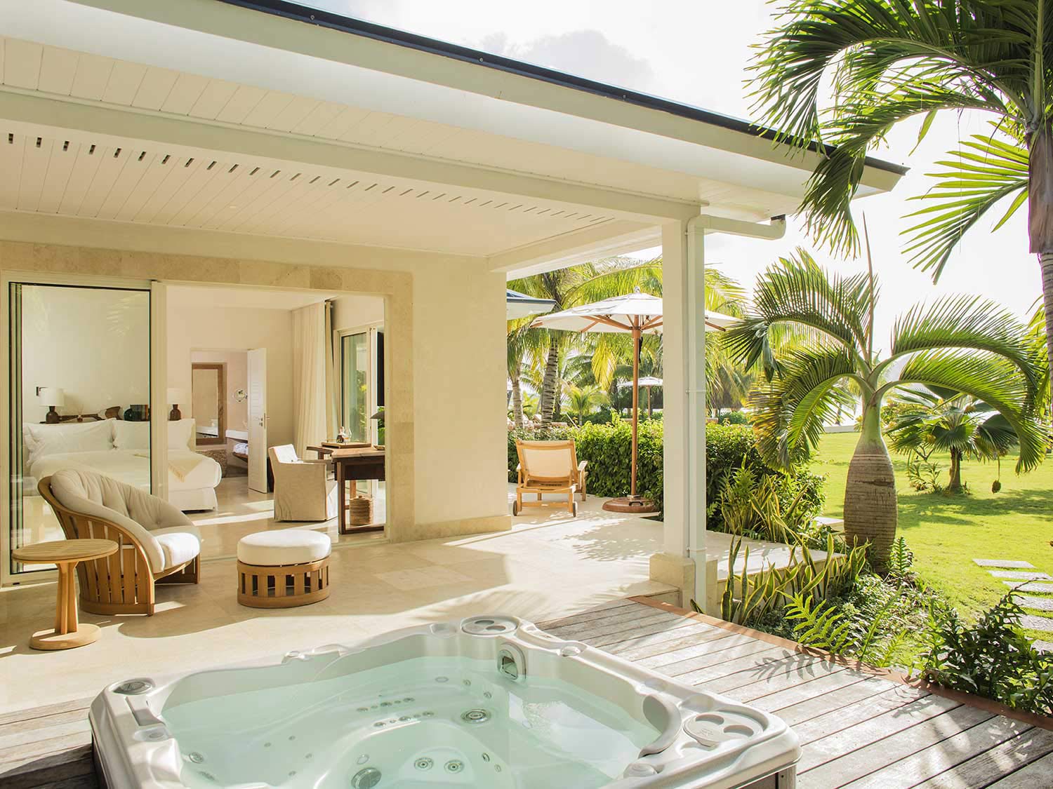 A luxurious, open air resort spa bedroom in Bora Bora, surrounded by palms and relaxing scenery.