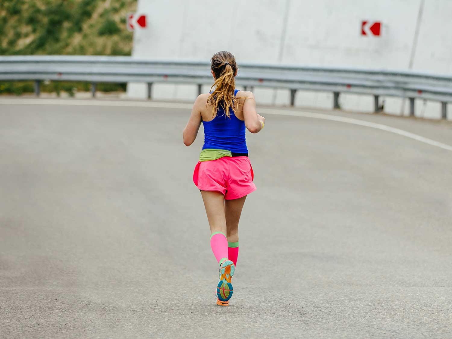Woman running while wearing compression socks.