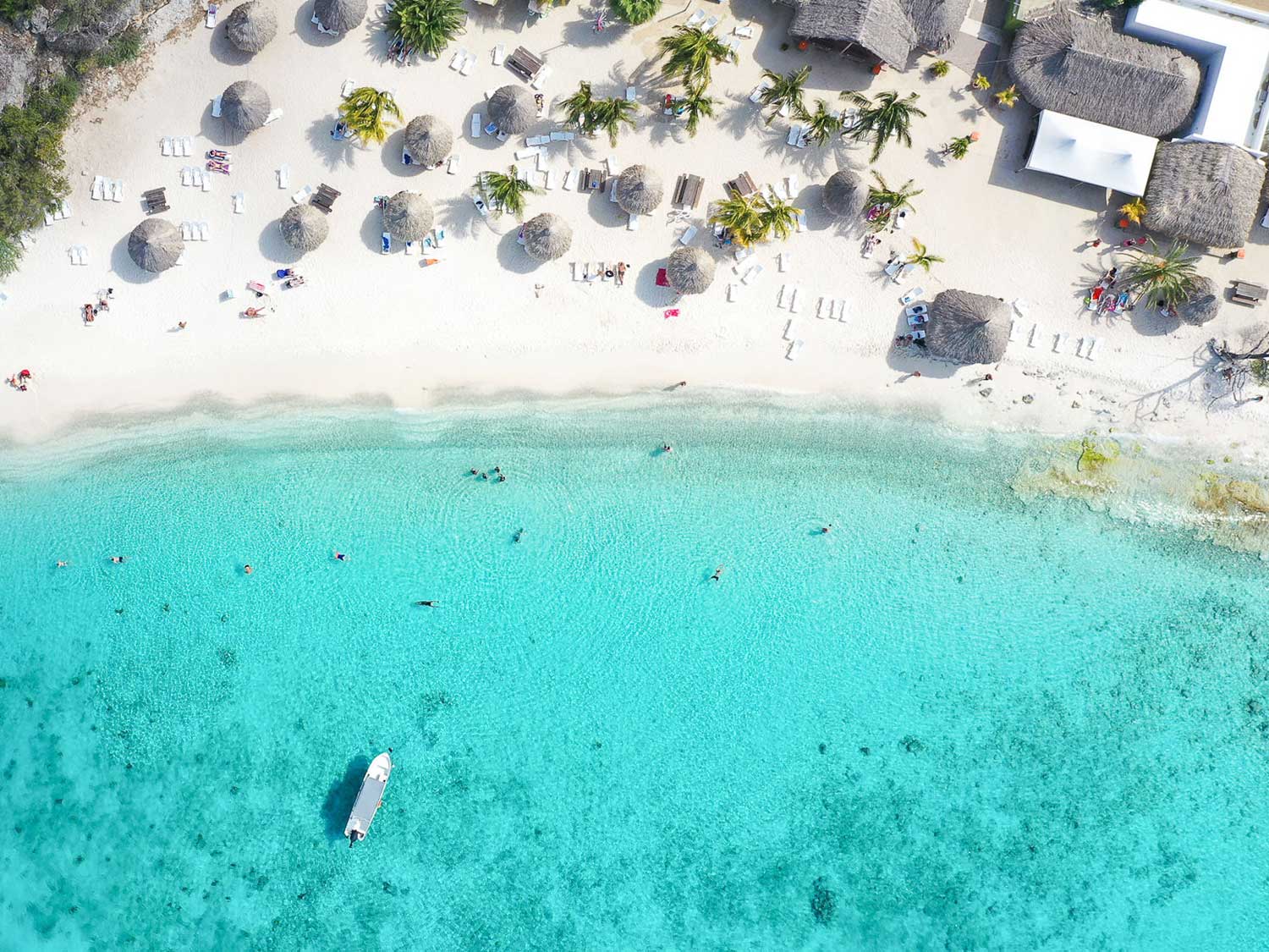 Aerial view of a crystal clear ocean waters off the shore of a beach resort.