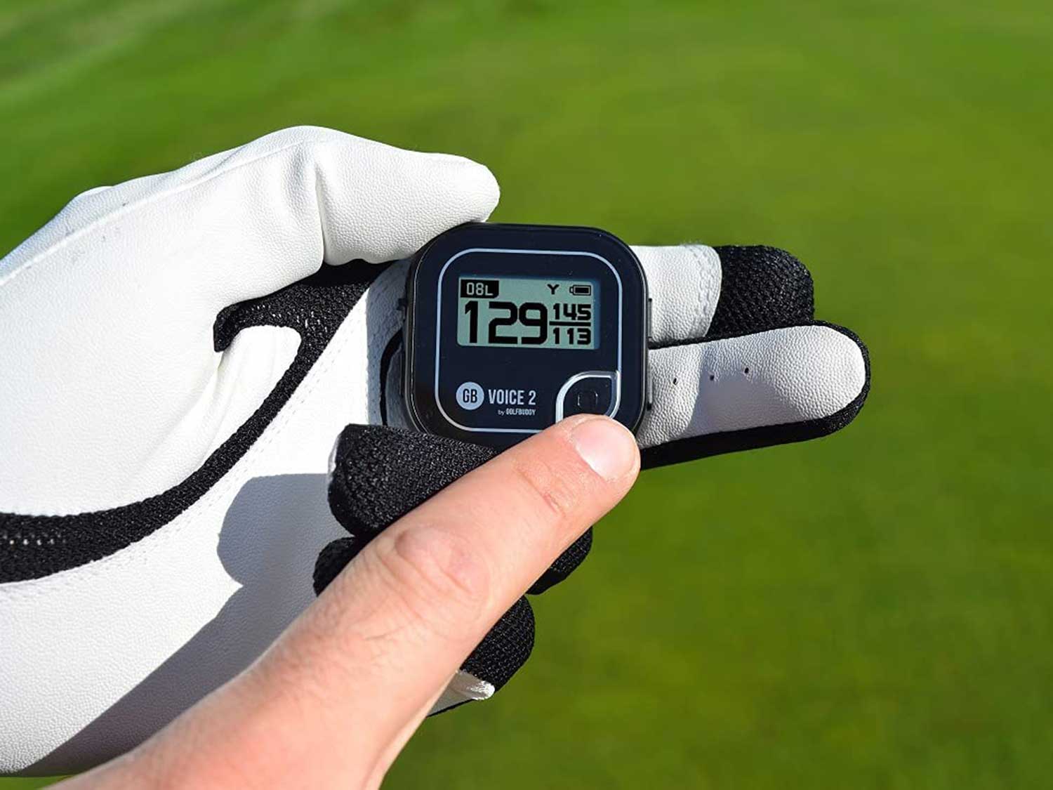 Gloved hand holding a golf GPS.