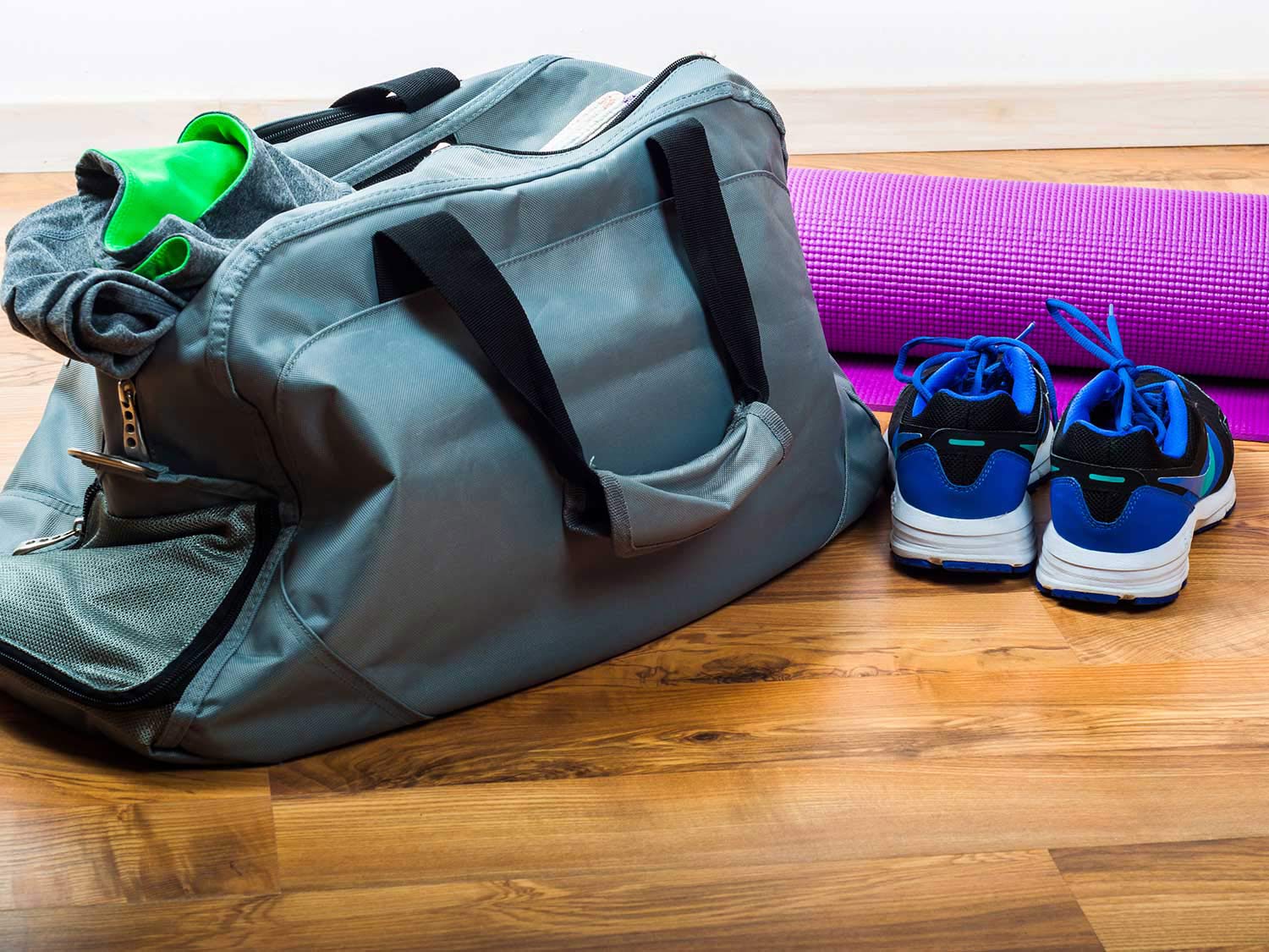 A gym bag with yoga mat and sneakers.