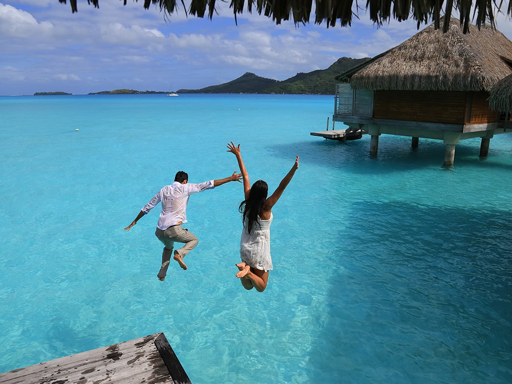 honeymoon couple jumping in ocean