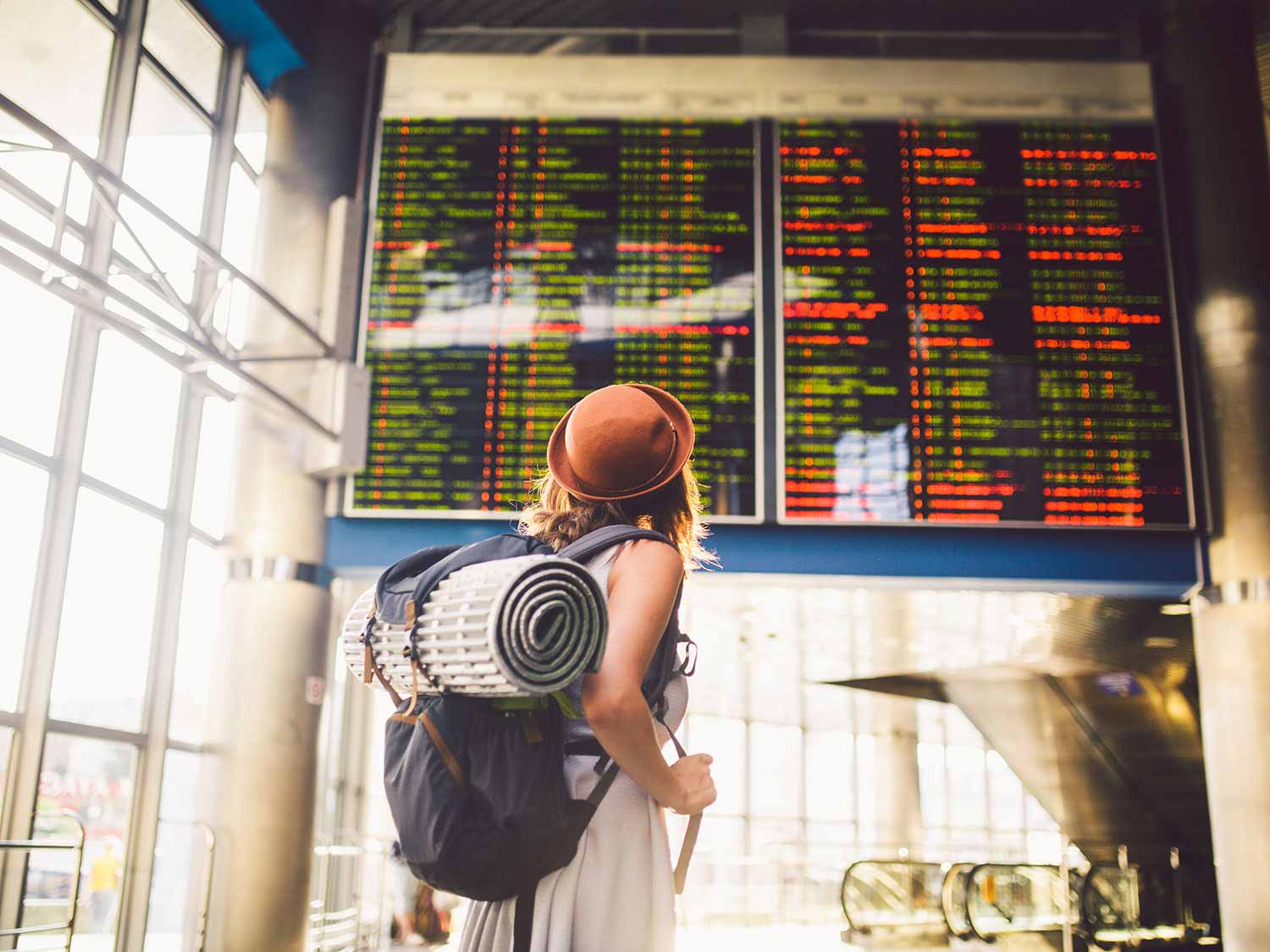 Traveler looking up at airport flight tracker board