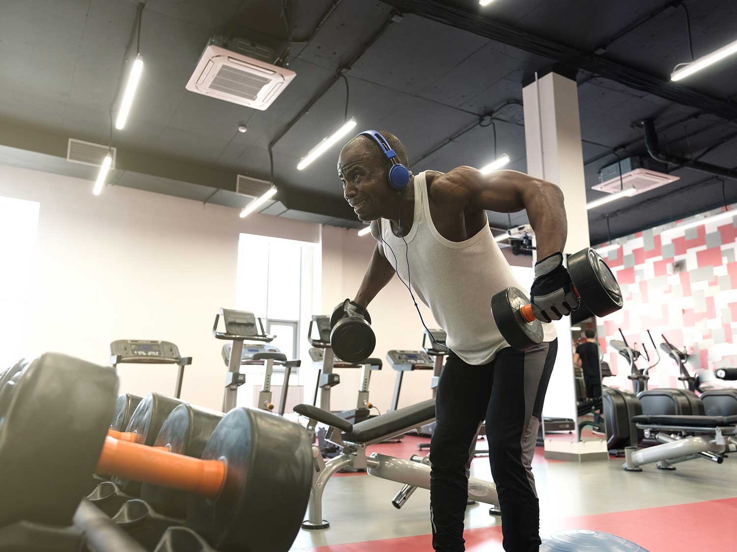 Guy working out at the gym wearing headphones