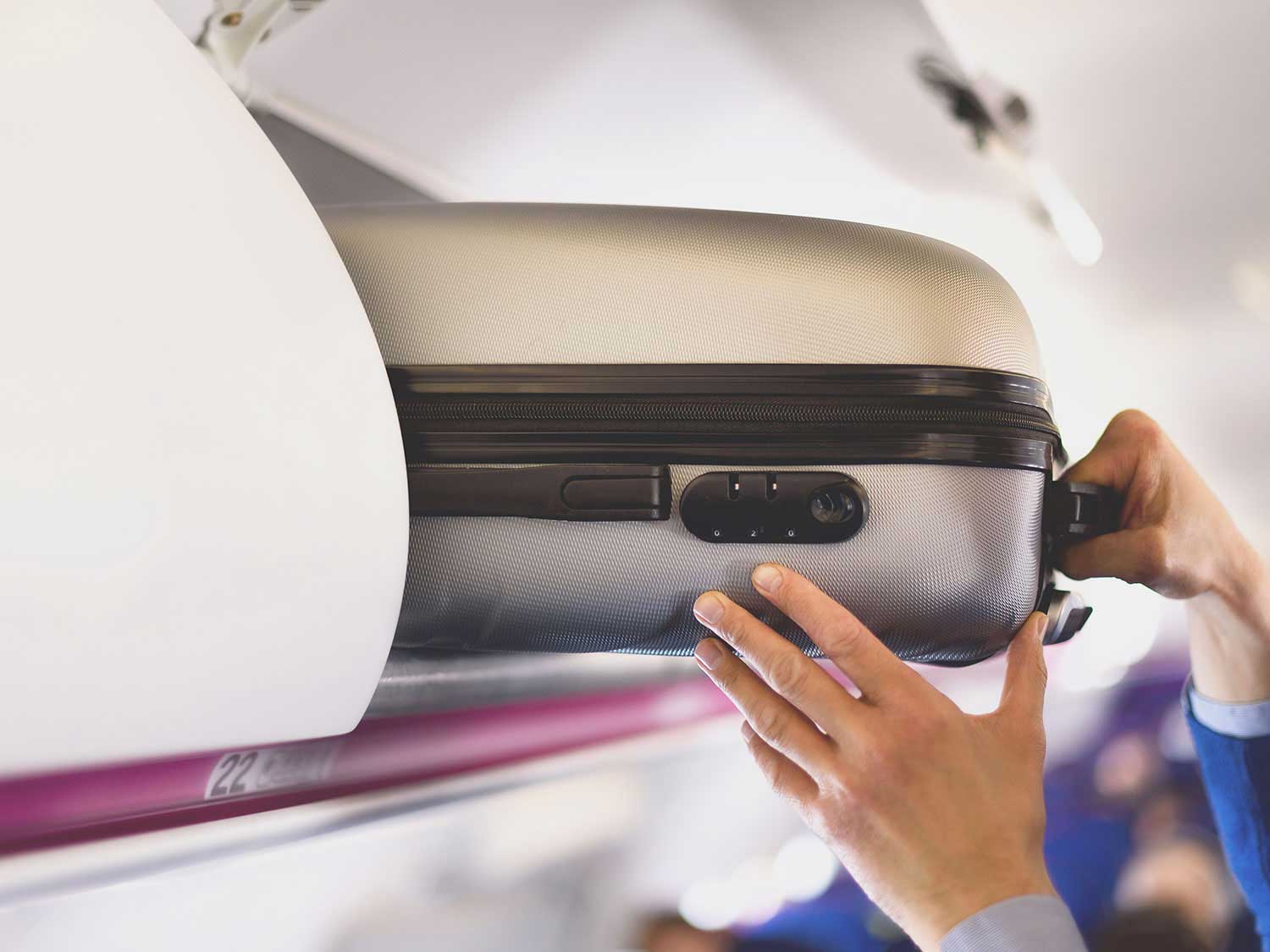 Person stowing luggage away on a flight