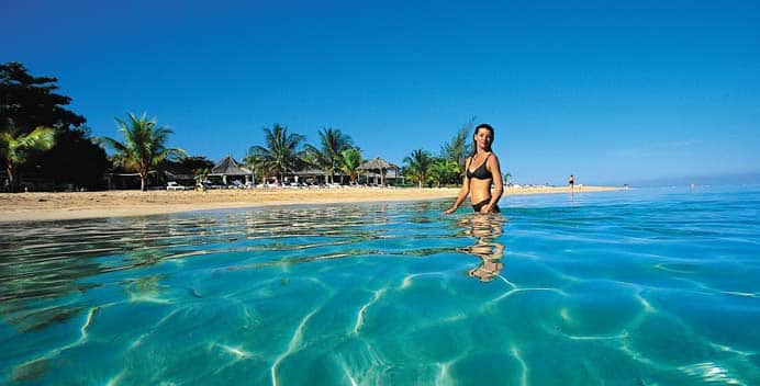 Woman wading in the ocean at Breezes Resorts, Jamaica, Bahamas, Curaçao