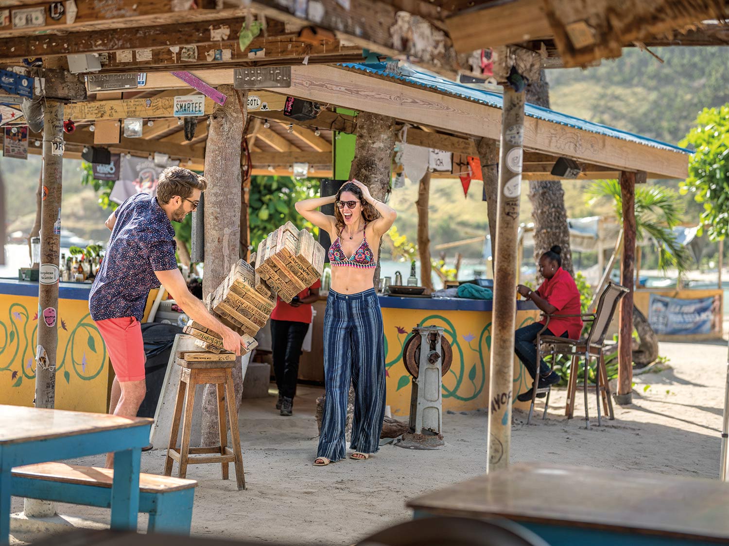 Two people play Jenga at a beach resort bar.