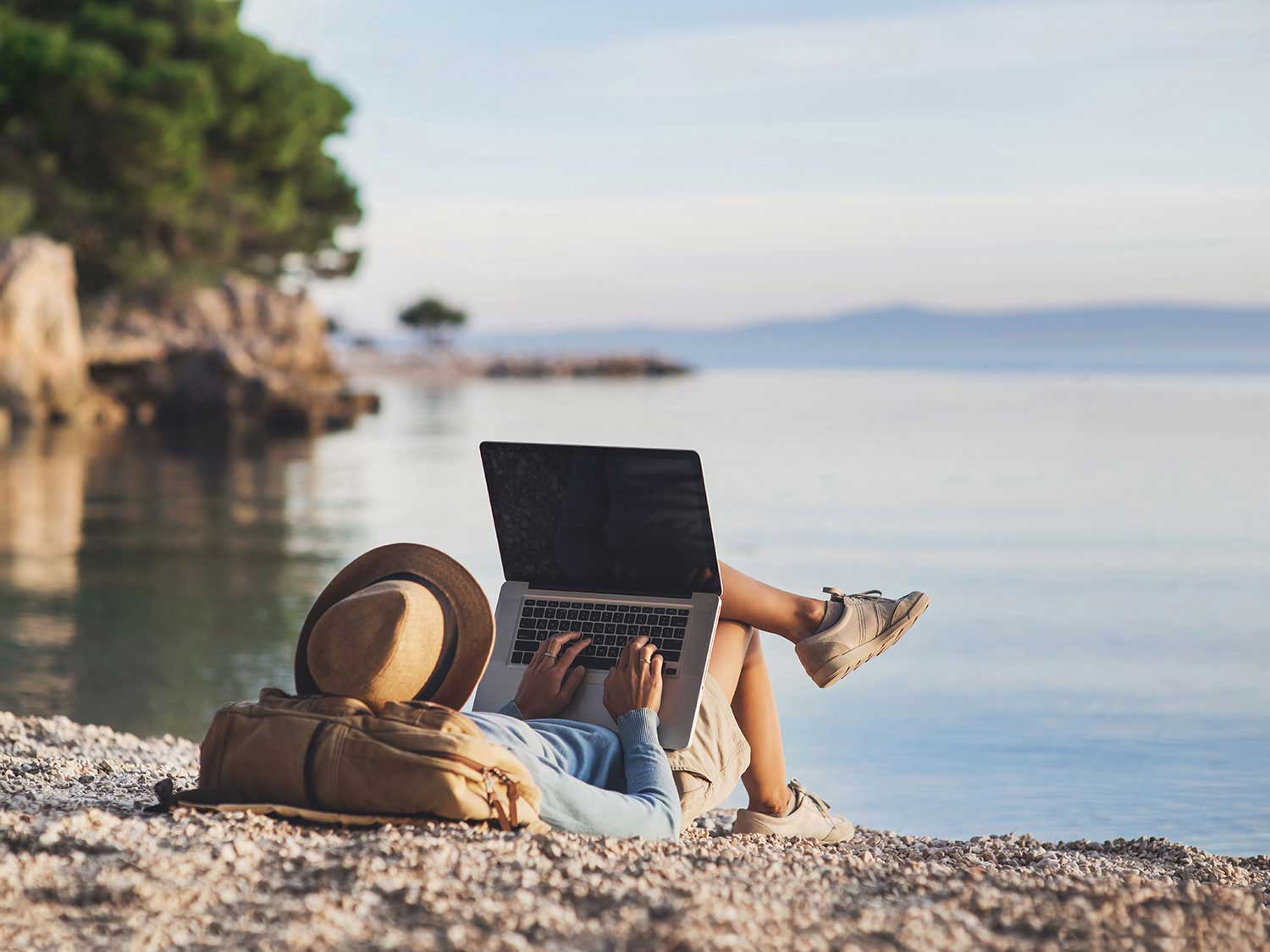 someone using a laptop on the beach