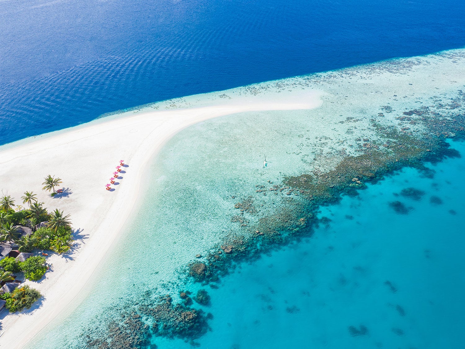 An aerial photo of a peninsula next to an island beach resort.