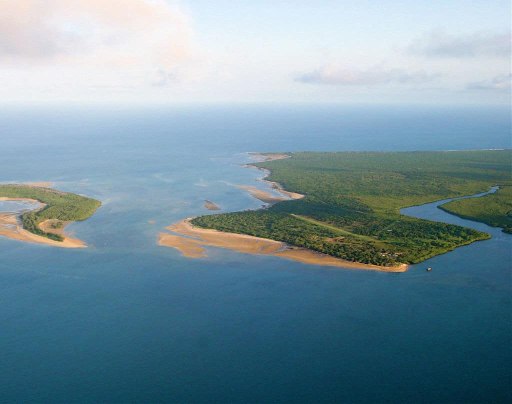 An aerial photo of a lush green island in the ocean.