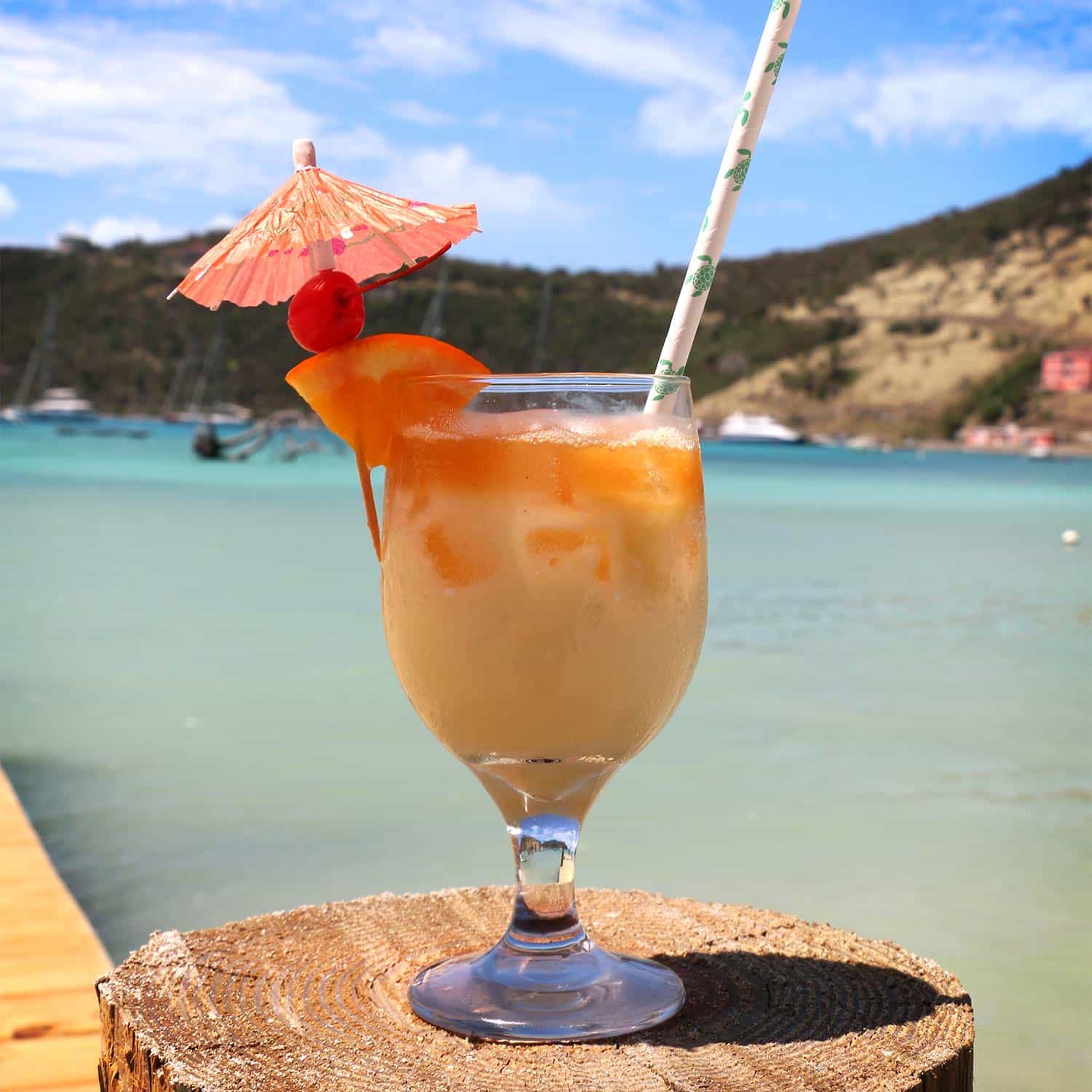 A tropical cocktail on a table by the beach.
