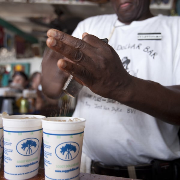 Bartender grates nutmeg over cocktail