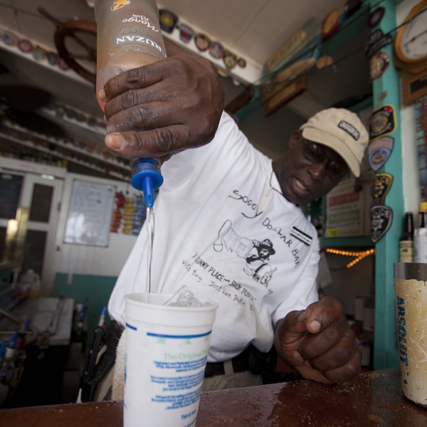 the bartender adds ingredients to the painkiller cocktail