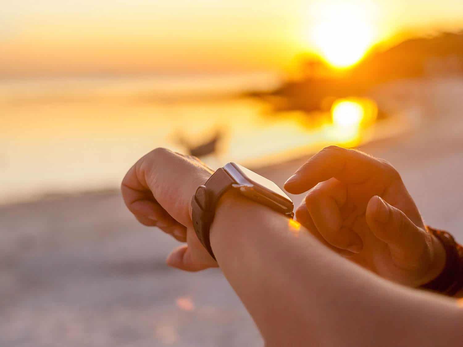 Person looking at watch at sunset
