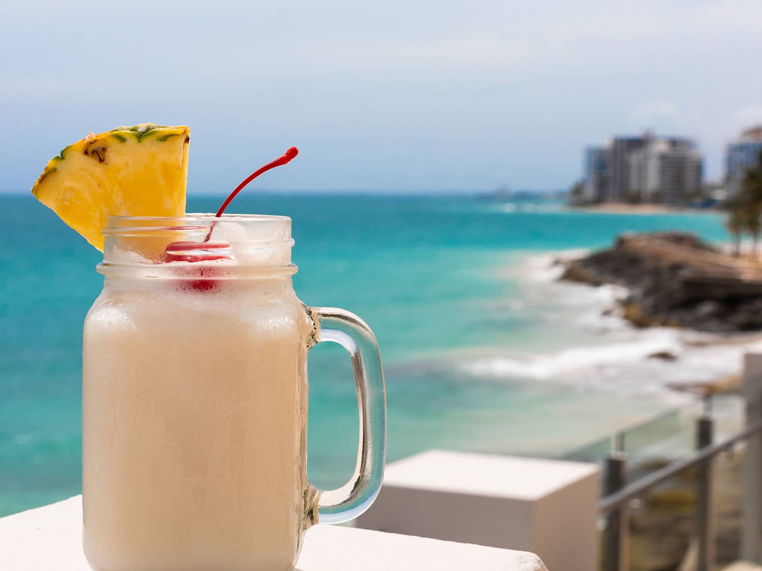 A pina colada on a beach side.