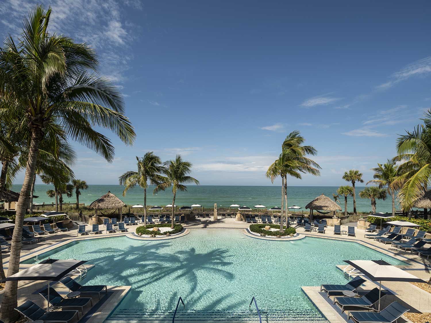 A beach side resort pool and lounge area.