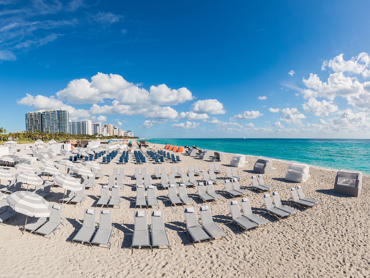 Lounge chairs lined up on the sand at The Shelbourne South Beach resort.