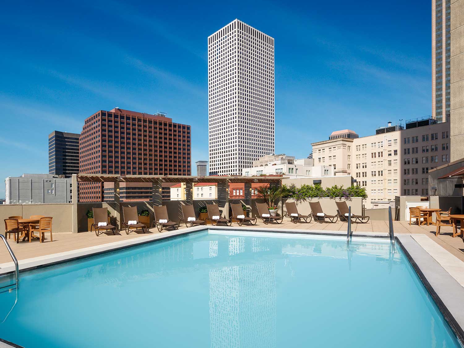 A cityscape on the horizon past a rooftop pool.