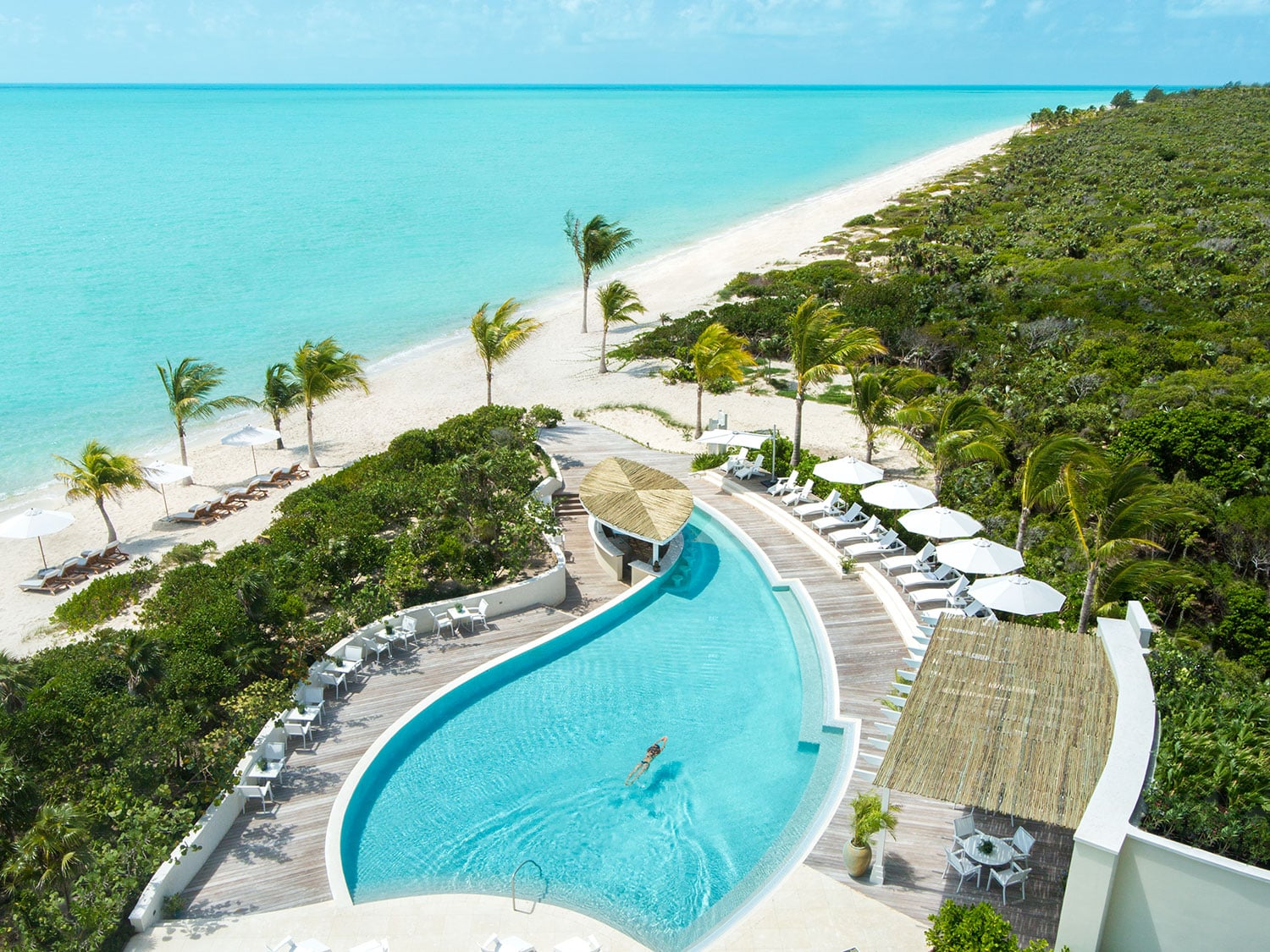A large pool near a beach-side resort.