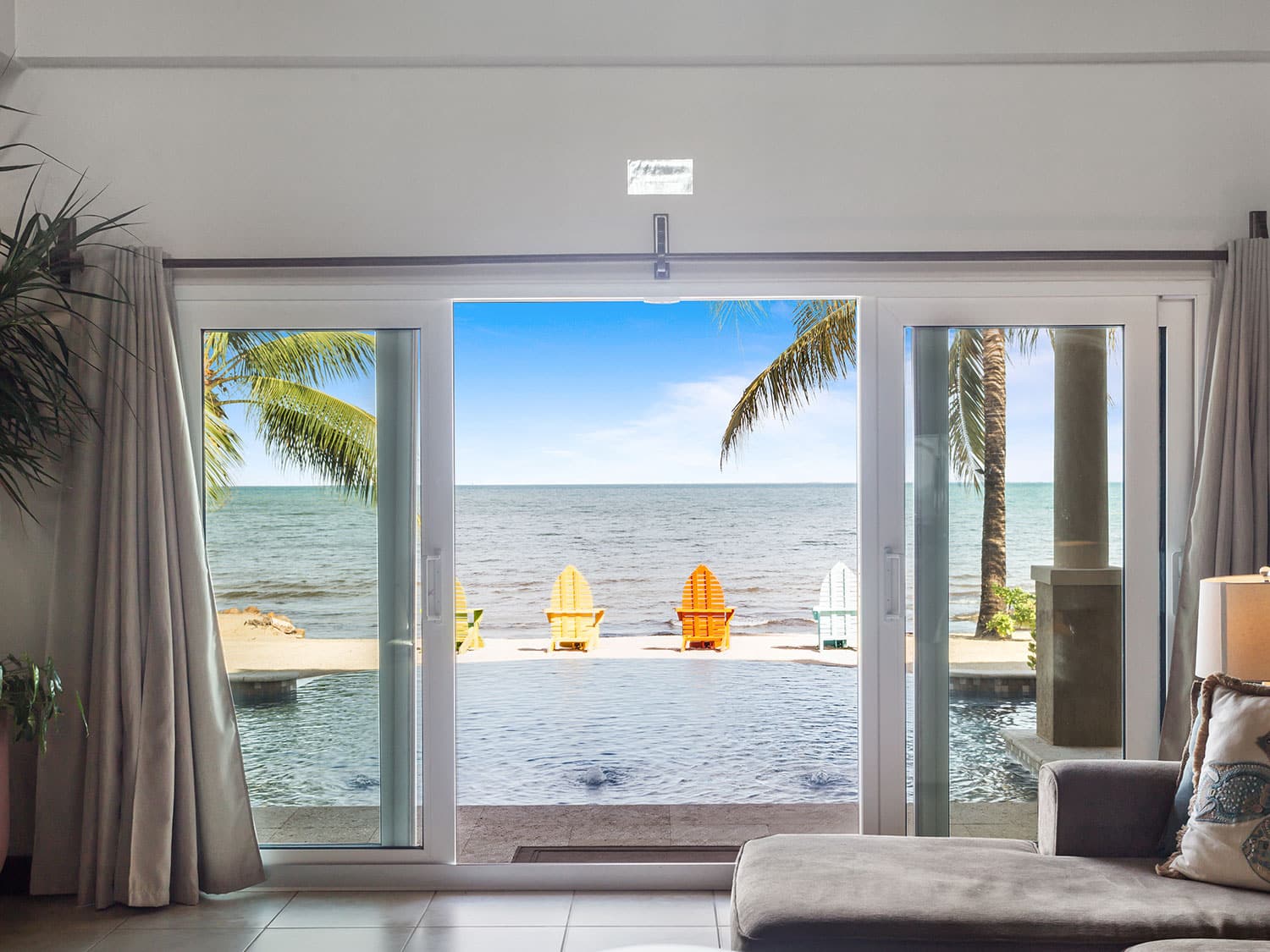 A large window overlooked a beach at an island bay resort villa.