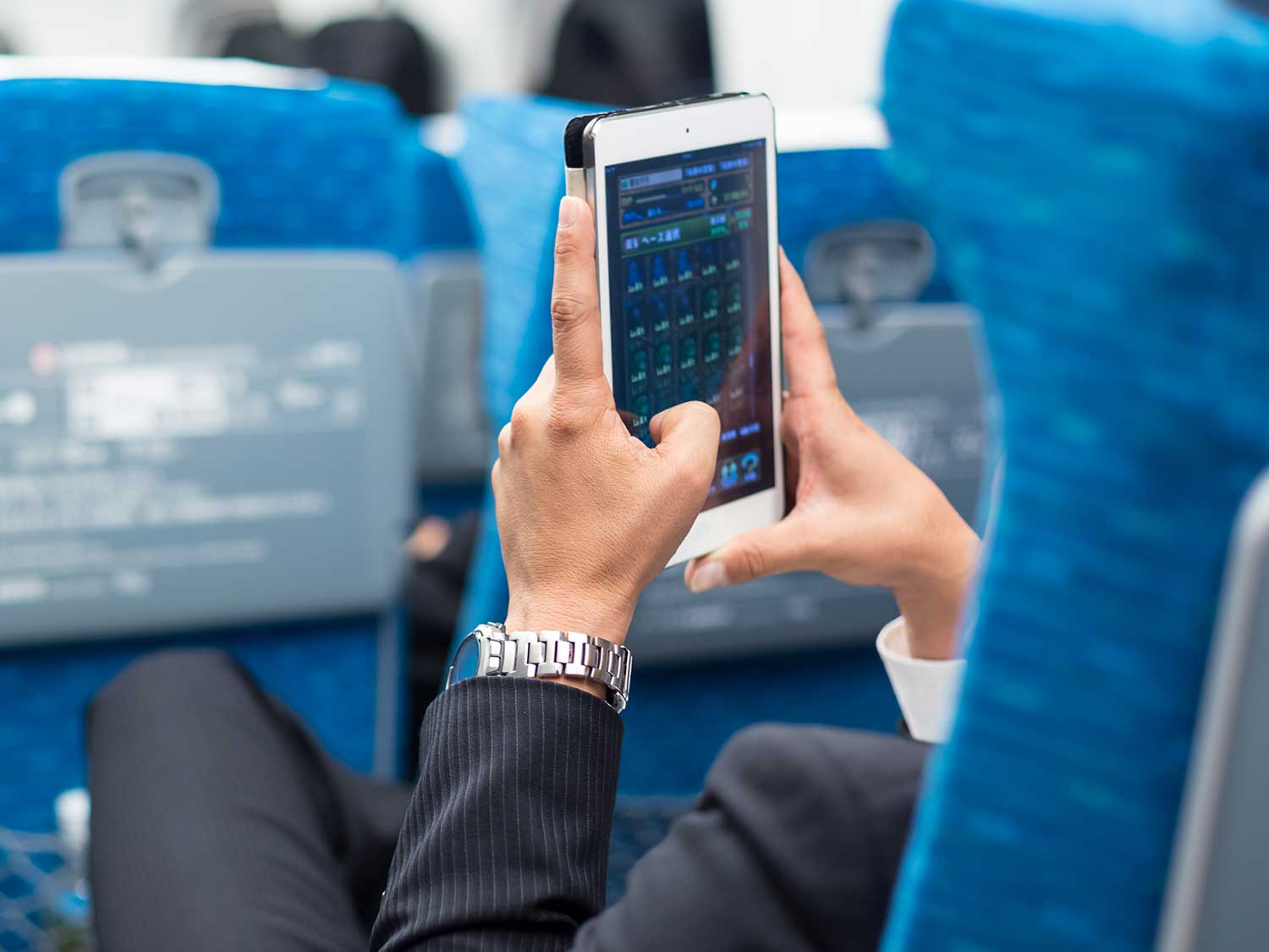Man using tablet on plane.