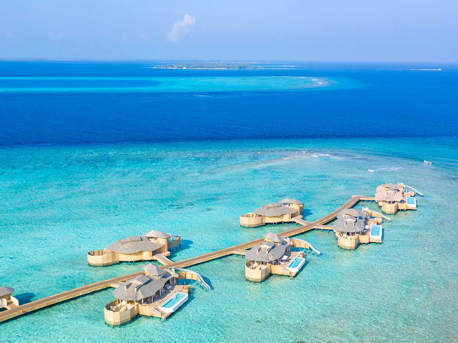 A long pier of resort-style island bungalos.