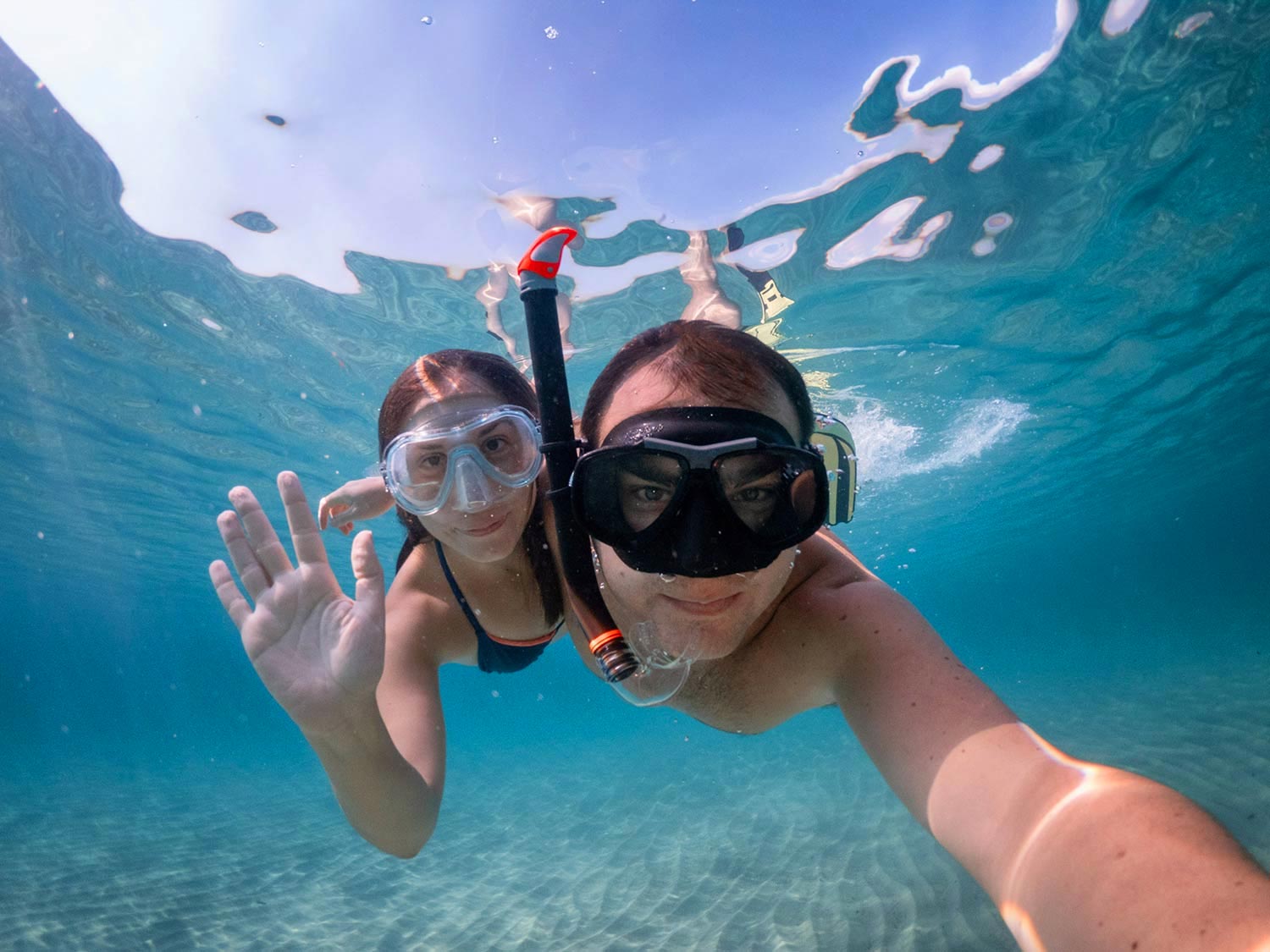 Teenagers swimming underwater with dive masks