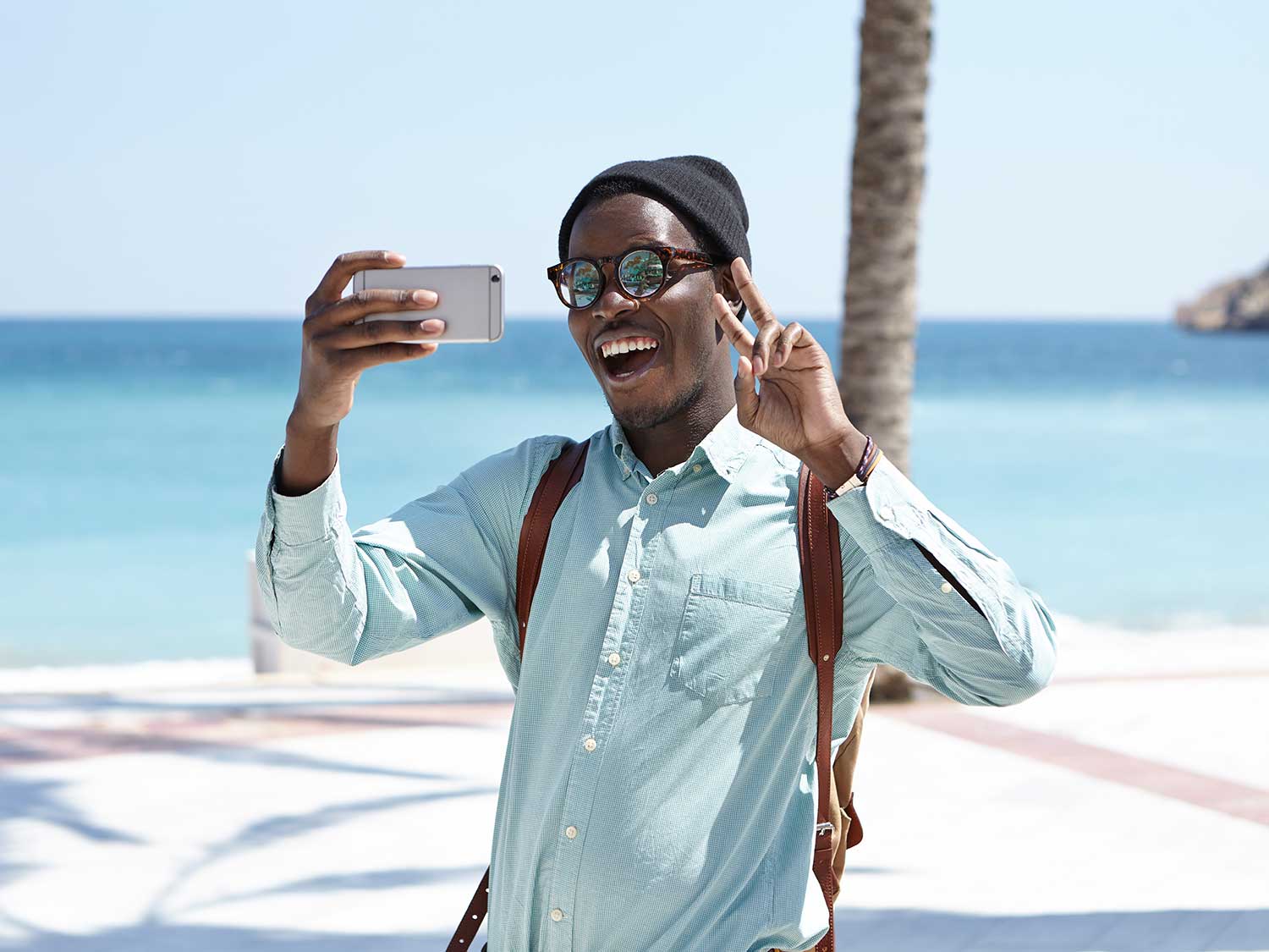 Man talking selfie on beach.