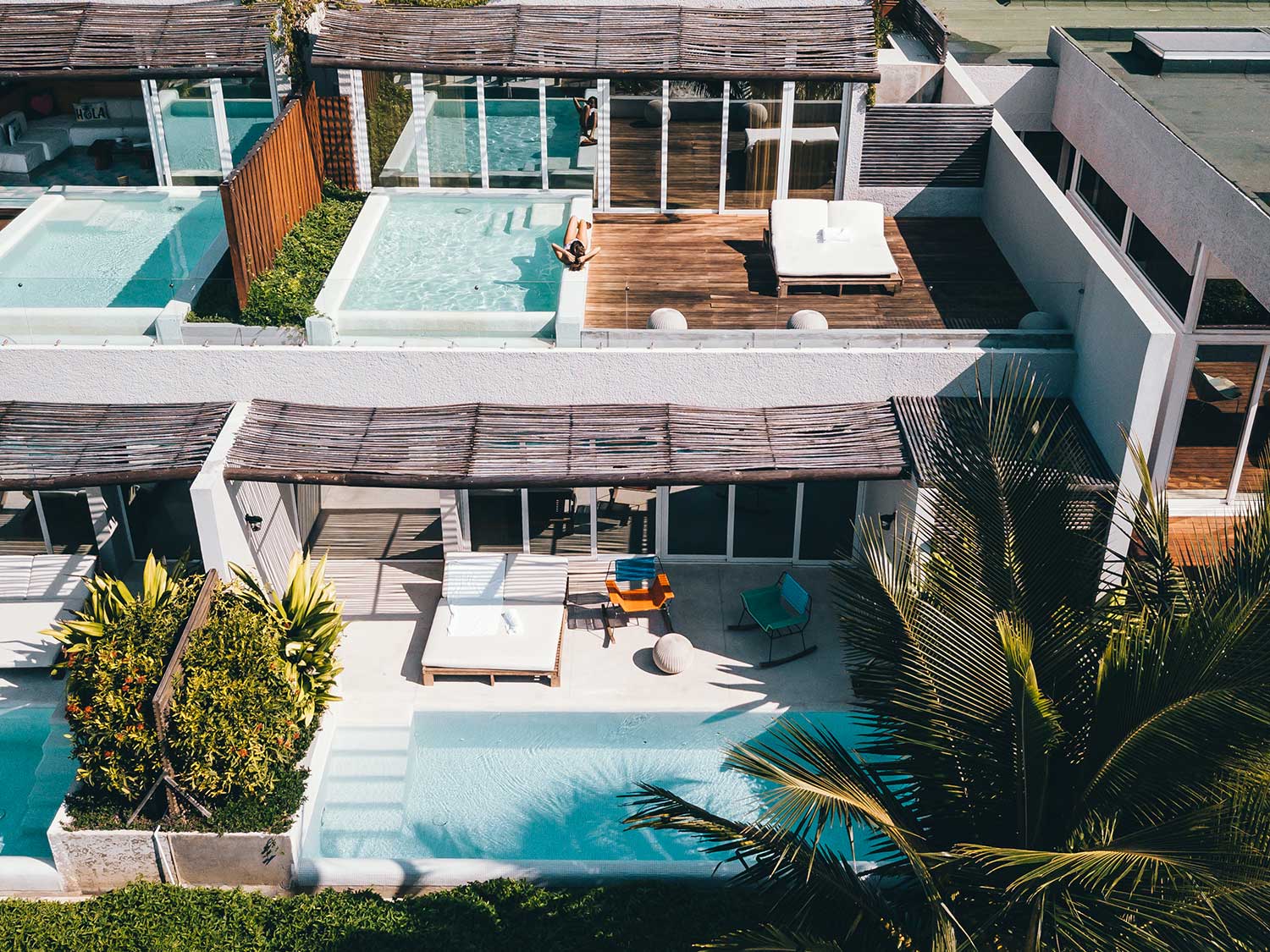 Pools and spas next to individual rooms at a beach resort.