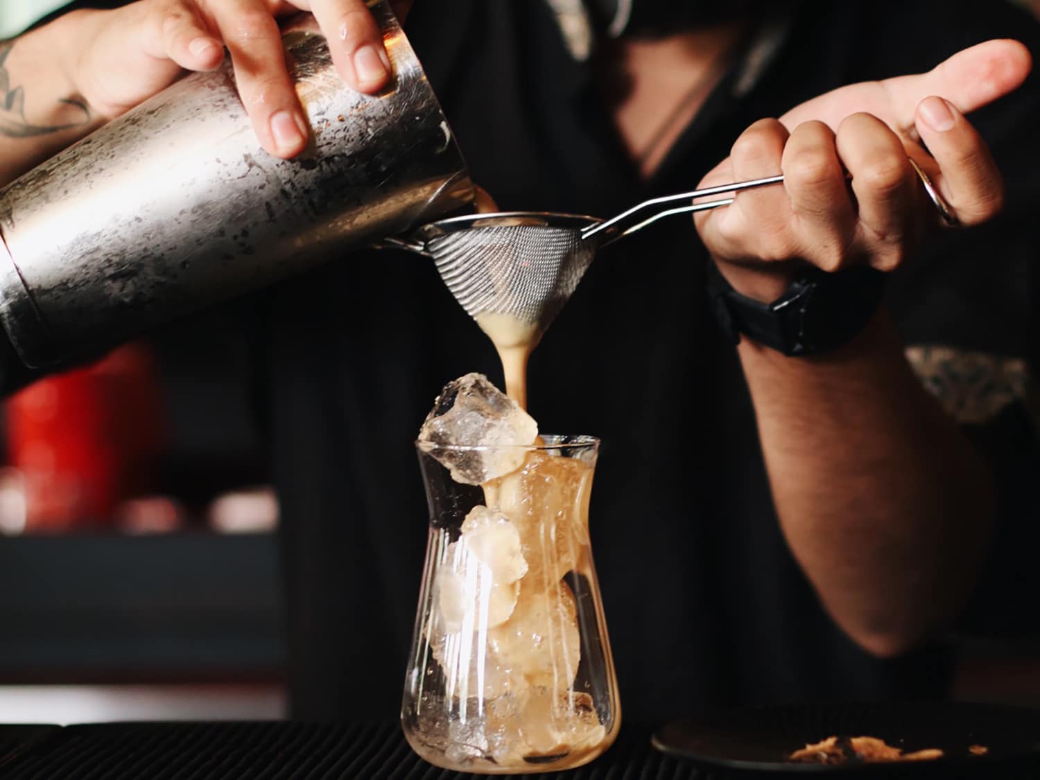 A bartender pouring an espresso martini