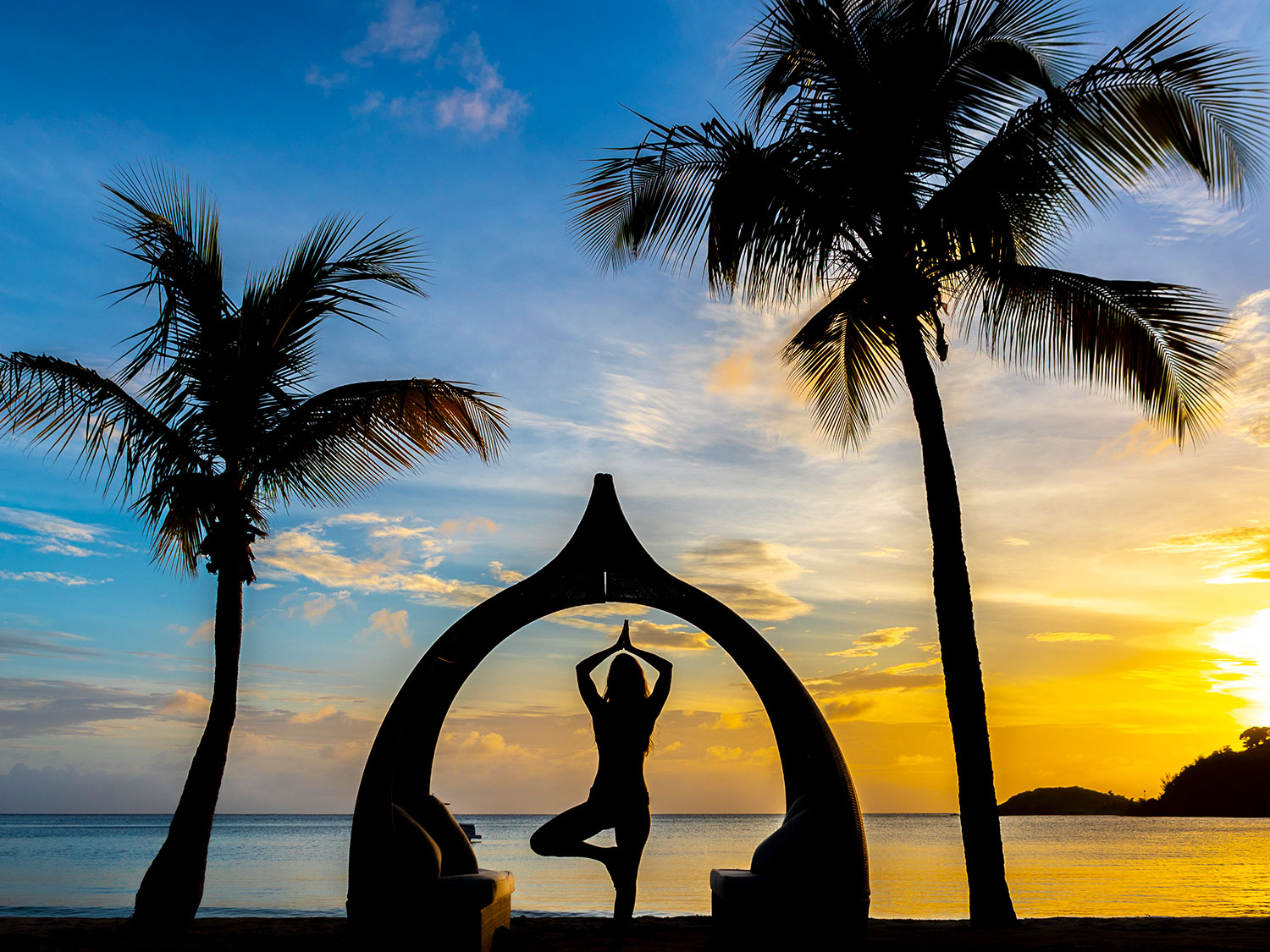 A person posing yoga on the beach of Carlisle Bay in Antigua