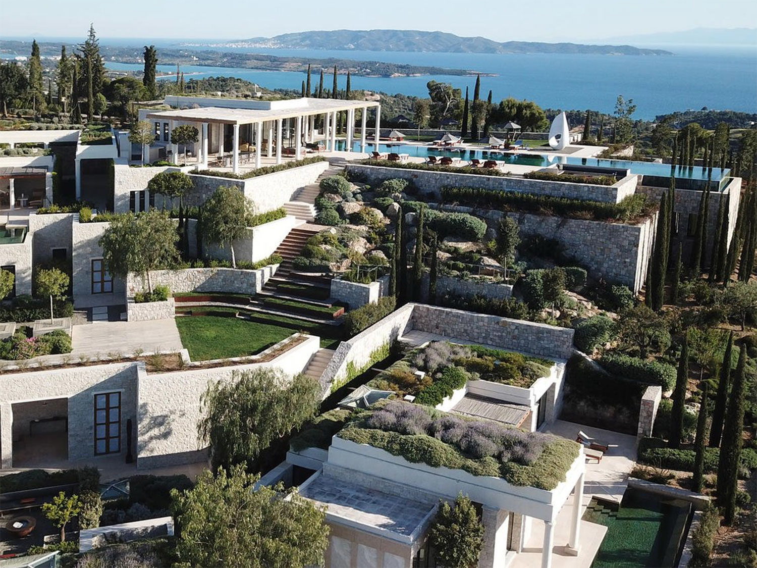 View of Amanzoe's Villa 20 property with the Aegean Sea in the background.