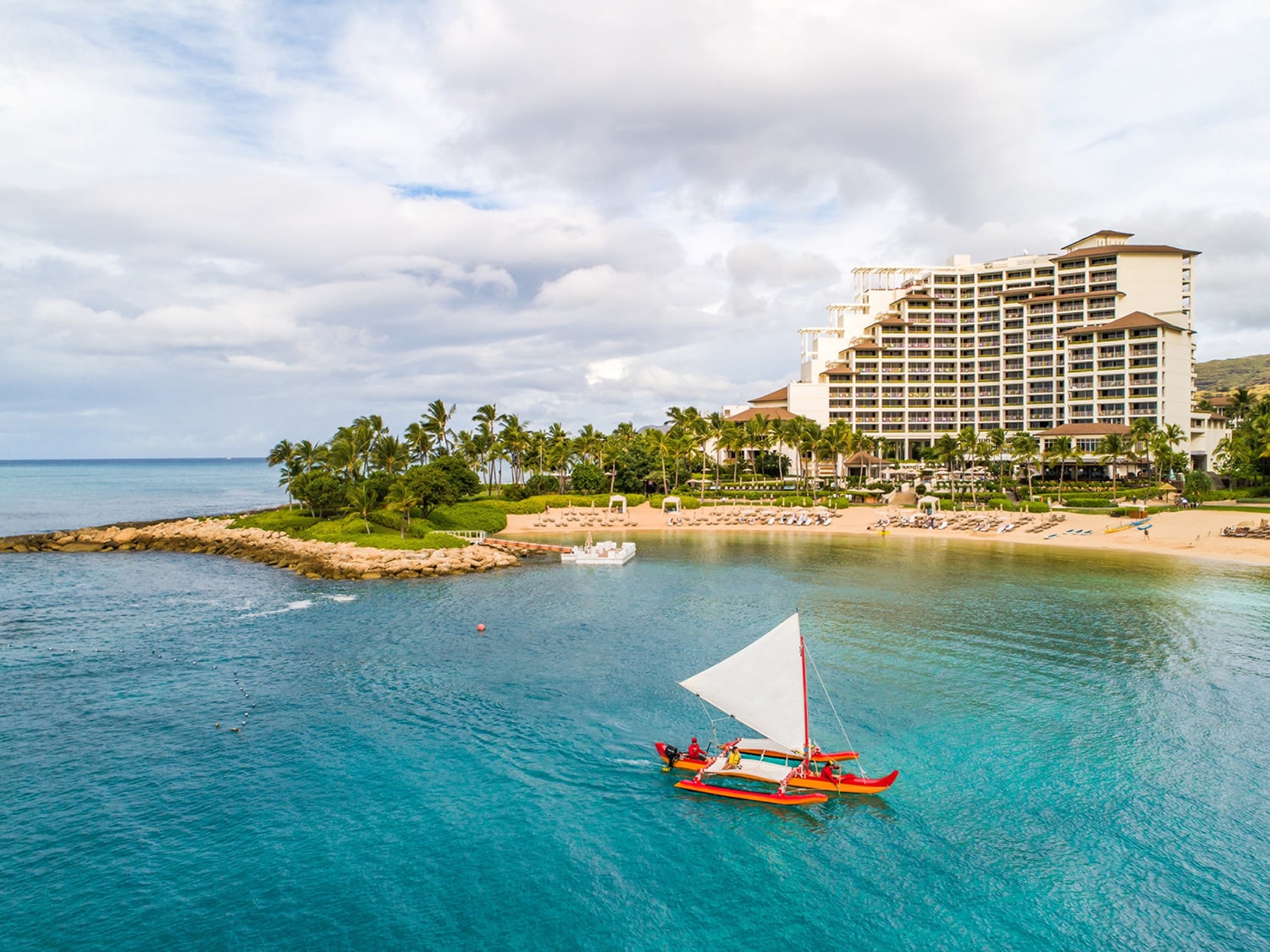 An outrigger canoe passes in front of The Four Seasons Resort at Ko Olina.