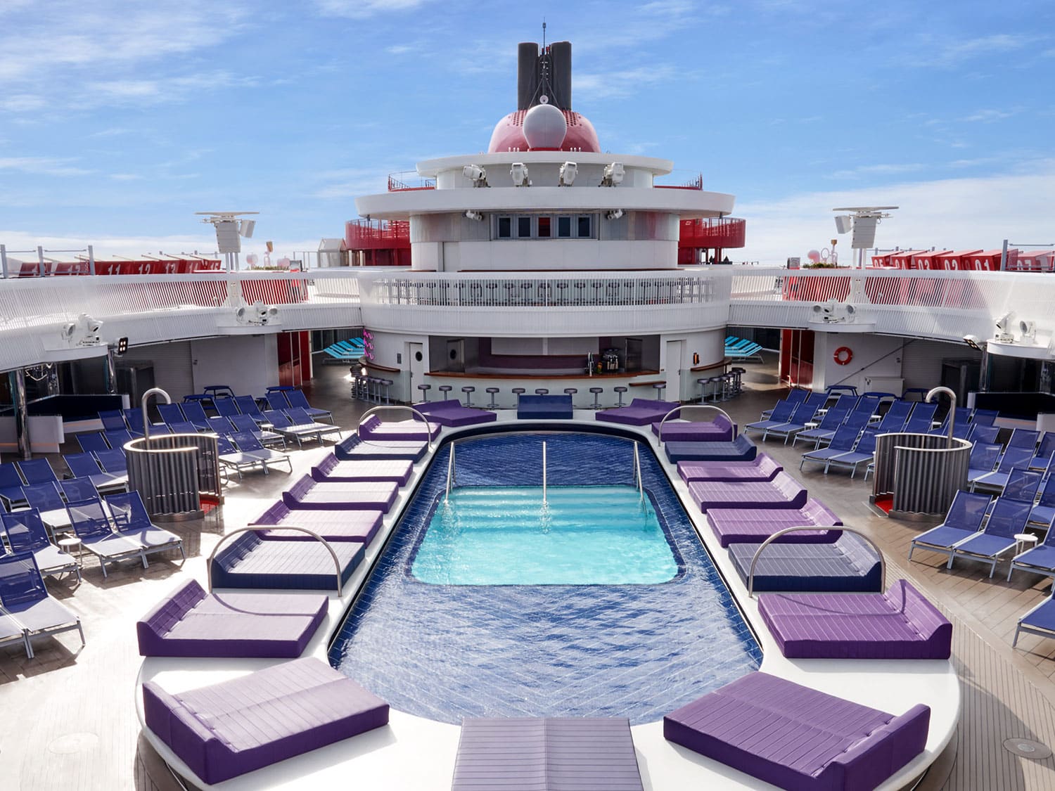 An aerial, empty view of one of the pools on the Virgin Voyages Valiant Lady.
