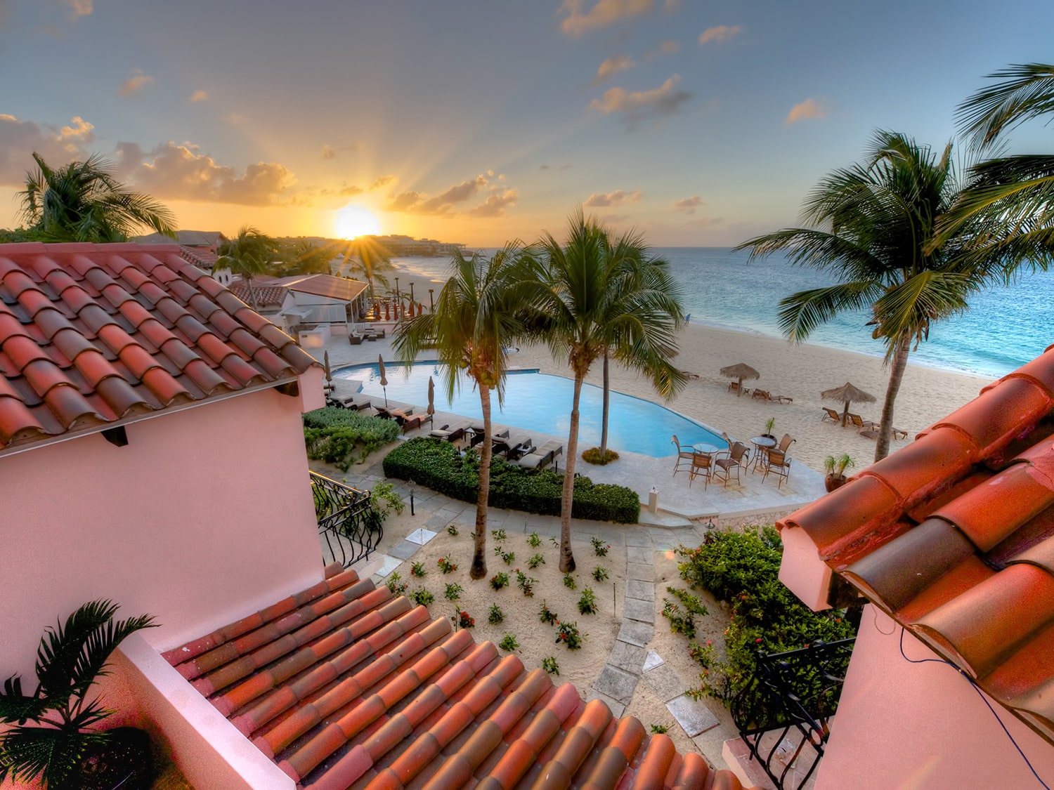 A sunset view of the pool and beach at Frangipani Beach Resort, located on Meads Bay in Anguilla.