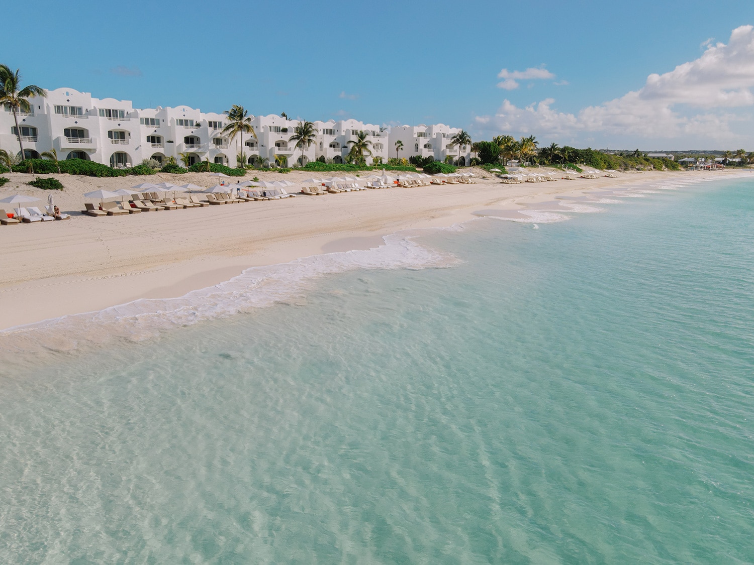 An exterior shot of Aurora Anguilla Golf Resort and Spa and its beautiful beach.