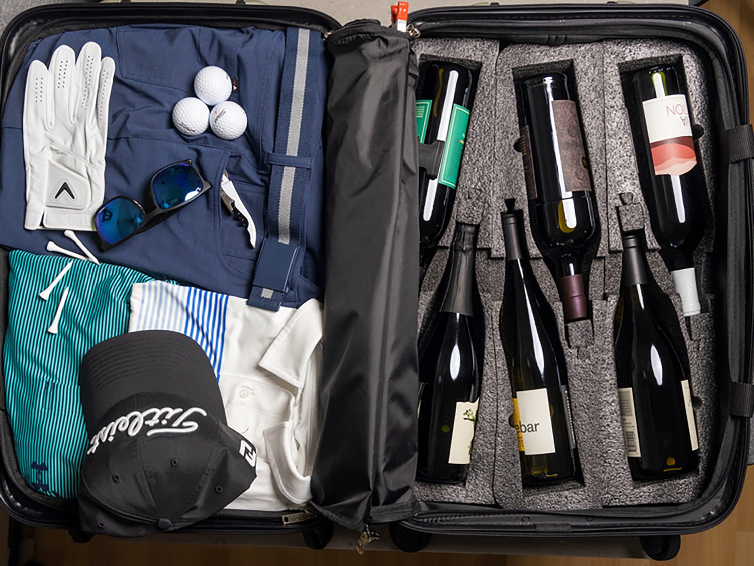 An interior look at a FlyWithWine VinGardeValise suitcase that features foam inserts to protect wine and spirits in flight.