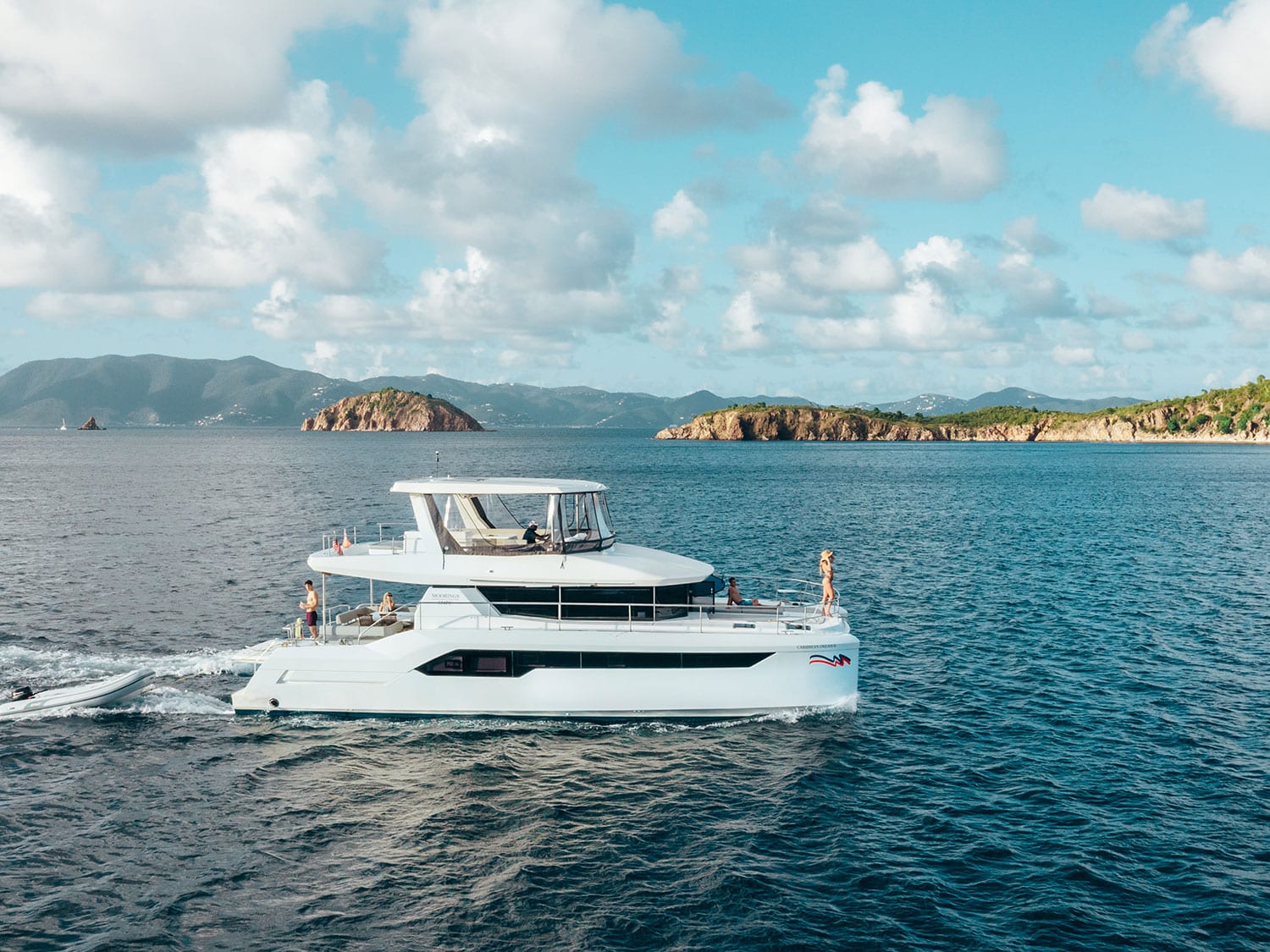 A group of friends sails on a crewed yacht charter with The Moorings, in the British Virgin Islands.