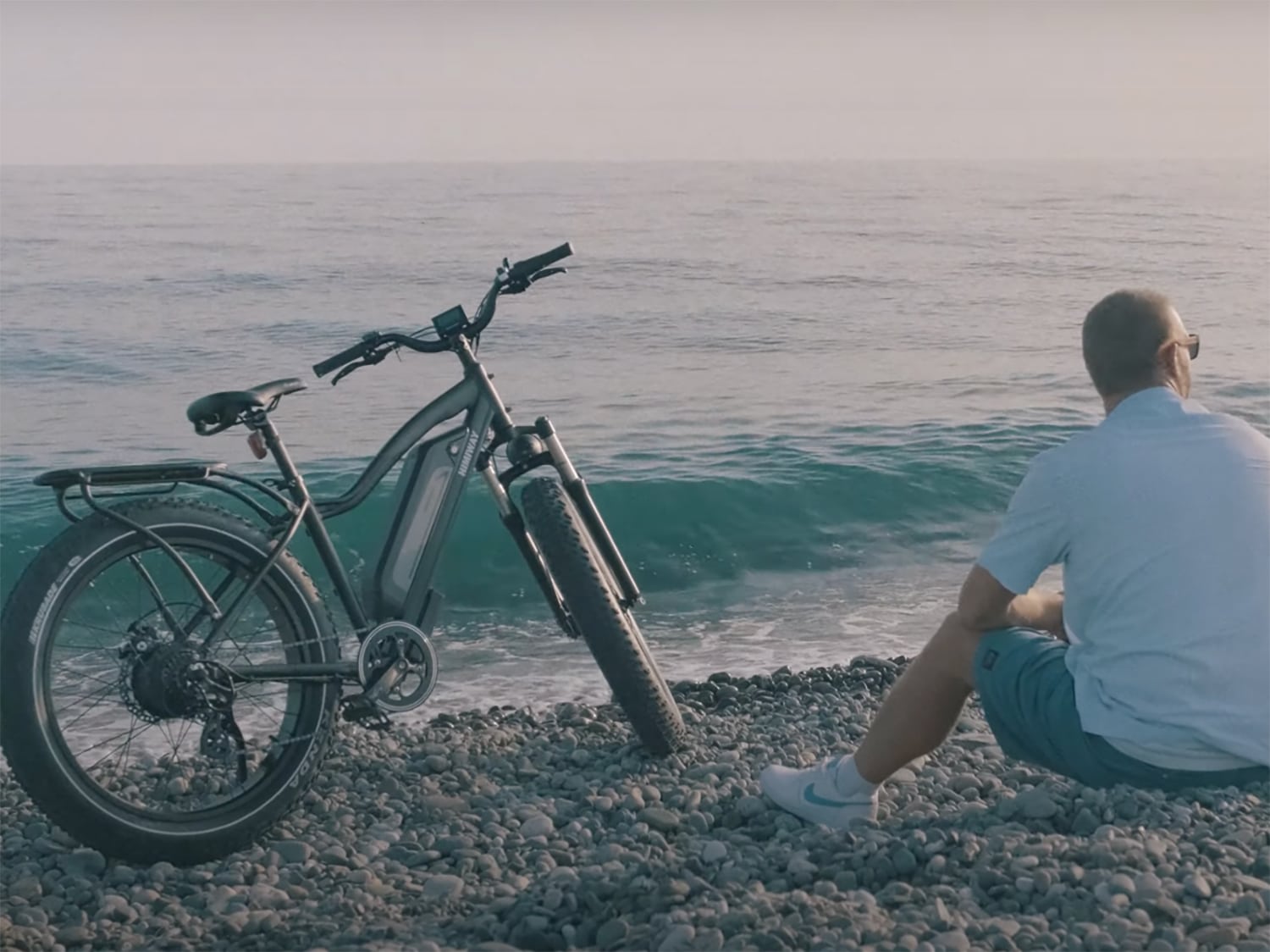 A man sitting next to a Himiway Cruiser electric bicycle.