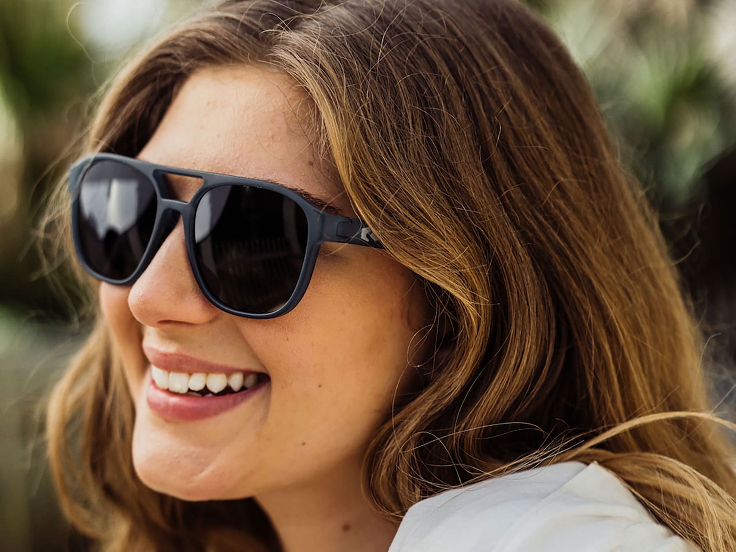 A woman wearing the Rheos Lanier unisex sunglasses.