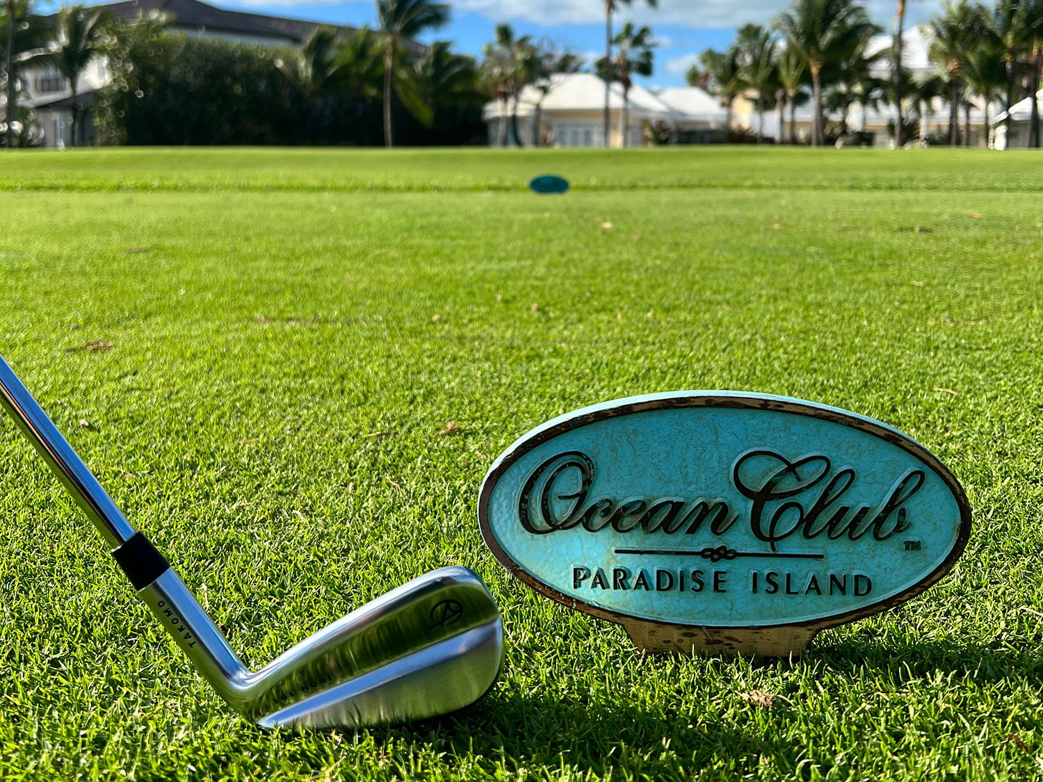 A Takomo 101 iron displayed next to a tee sign at the Ocean Club Golf Course in the Bahamas.