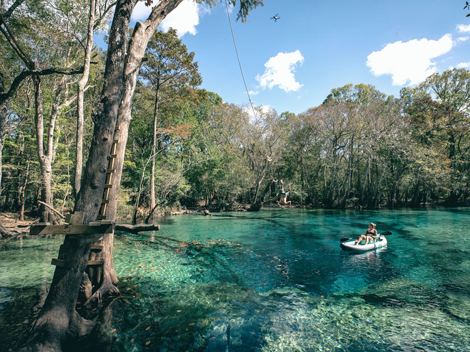 A woman paddling a Bote inflatable LONO Aero kayak on a river.