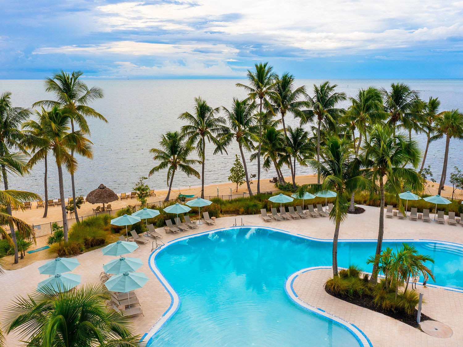 The pool and beach chairs that overlook the adjacent water at Amara Cay Resort in Islamorada, Florida.