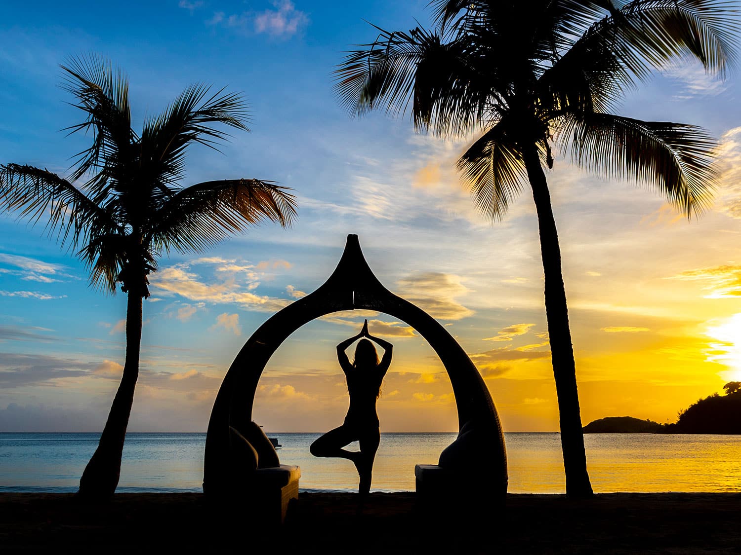The silhouette of a woman practicing yoga at the Carlisle Bay resort on the Caribbean island of Antigua.