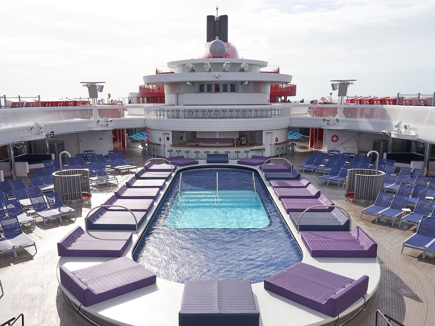 A view of the empty pool area aboard the Virgin Voyages Scarlet Lady cruise ship.