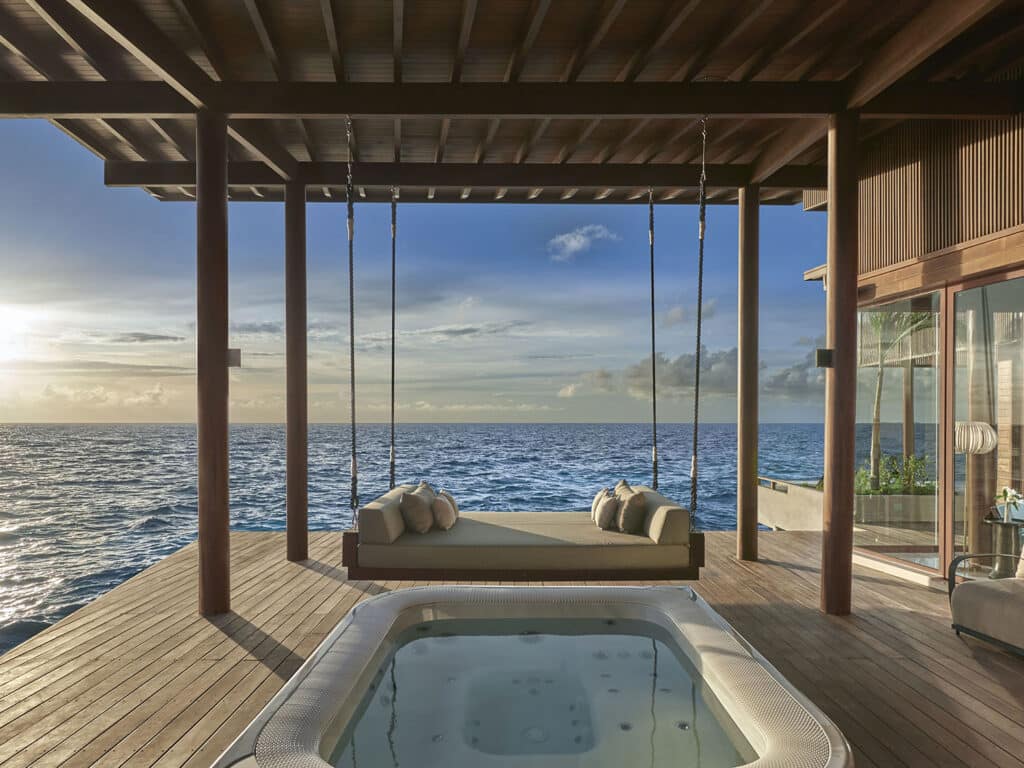 The outdoor whirlpool and hanging chairs of the Overwater Reef Residence at Park Hyatt Maldives Hadahaa.